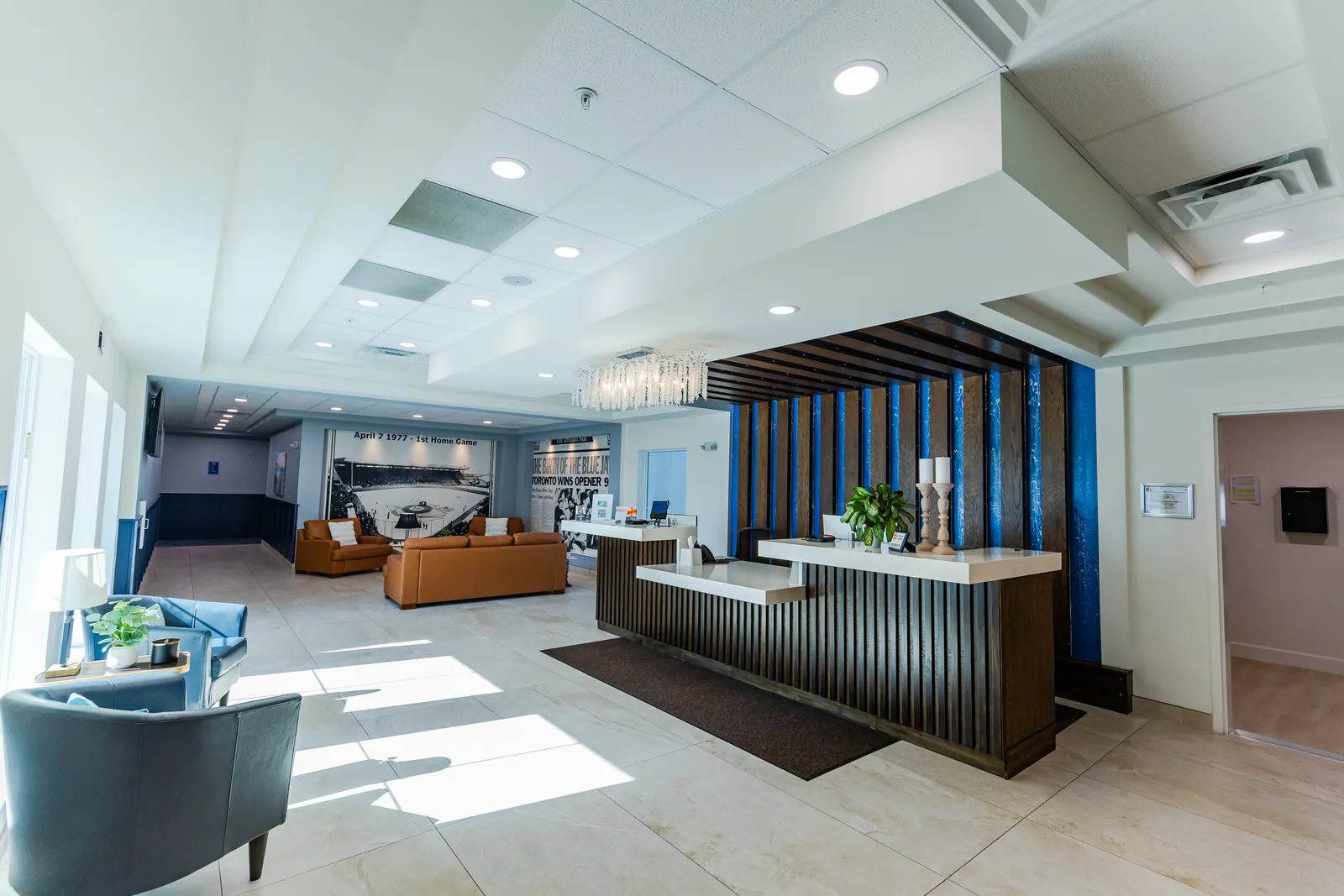 The lobby, with seating, the front desk and Blue Jays photo murals