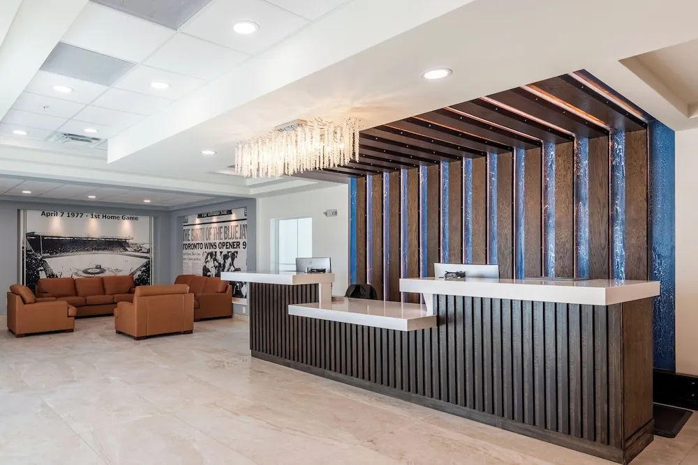 The J Hotel lobby with a wood slat front desk, crystal chandelier and baseball photo murals